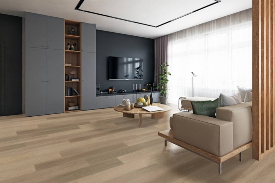 warm toned wood look laminate flooring in living room with tan couch, wood coffee table, and black accent wall.